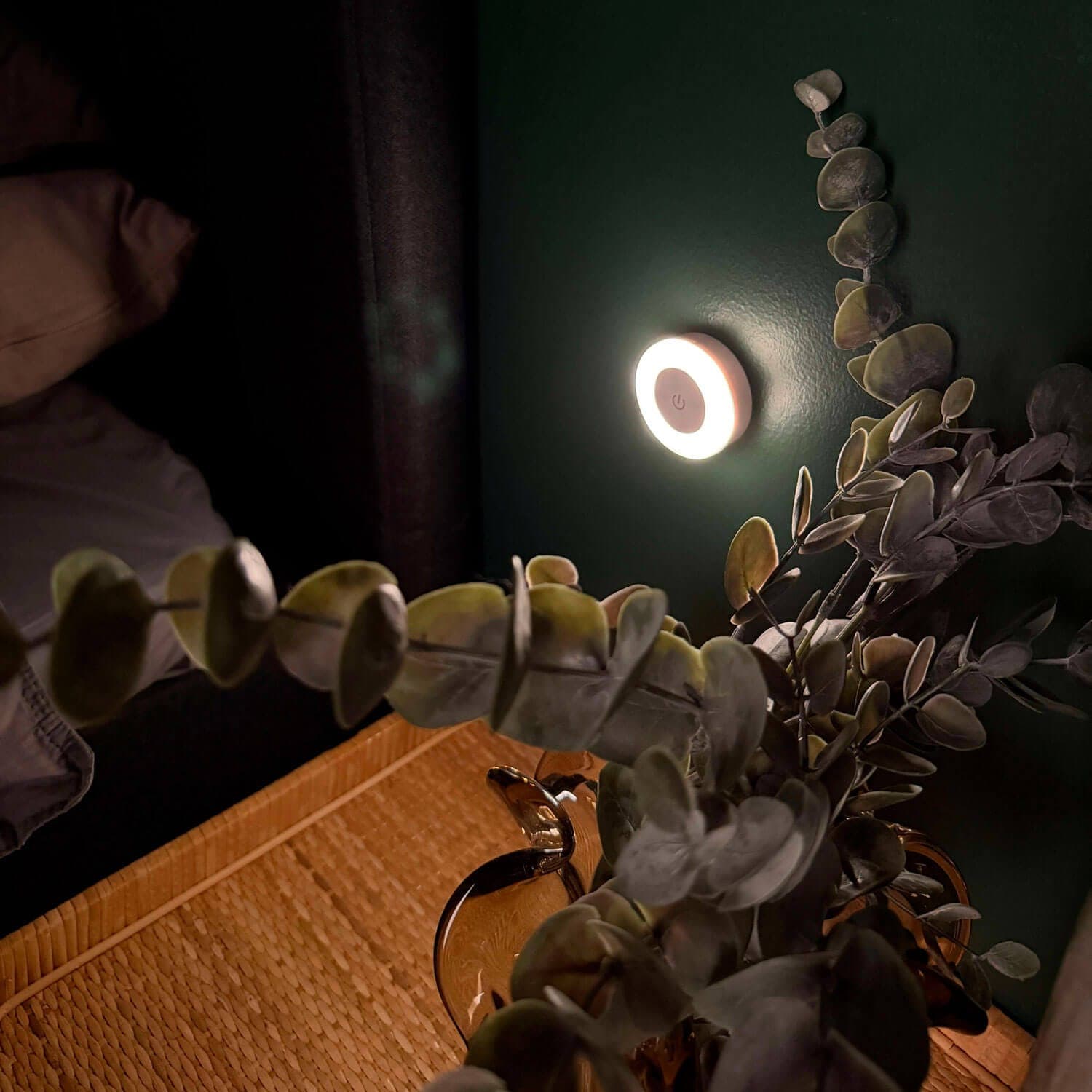 Lampe d’allaitement ronde diffusant une lumière tamisée sur le mur près du lit, la nuit