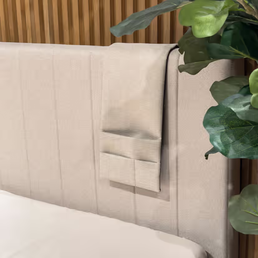 Pochette de lit beige à trois compartiments, suspendue au bord de la tête de lit