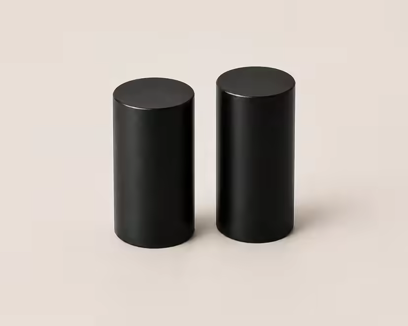 Deux pieds centraux noirs cylindriques sur une surface claire